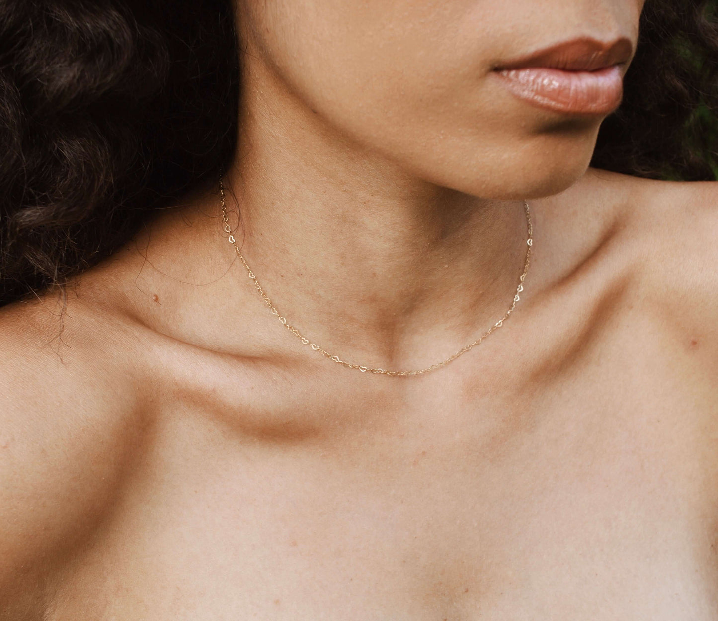 Model wearing the Velani Jewelry Gold Filled Dainty Flat Heart Necklace, showcasing its elegant design for everyday wear.