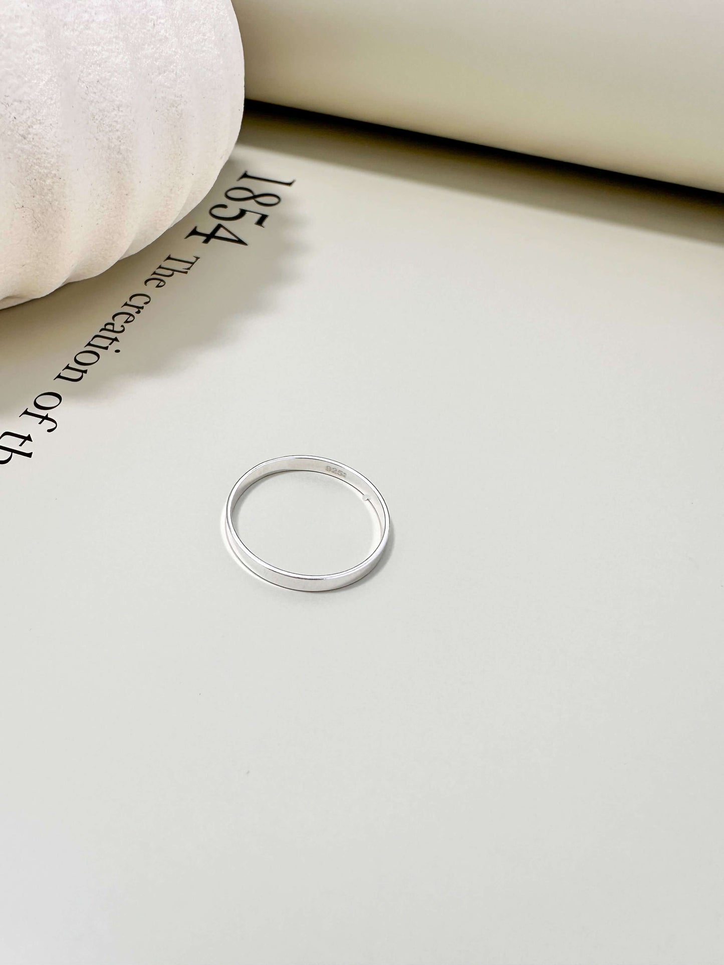 14K gold filled and hypoallergenic flat band ring on a soft surface, tarnish resistant and waterproof for everyday wear.