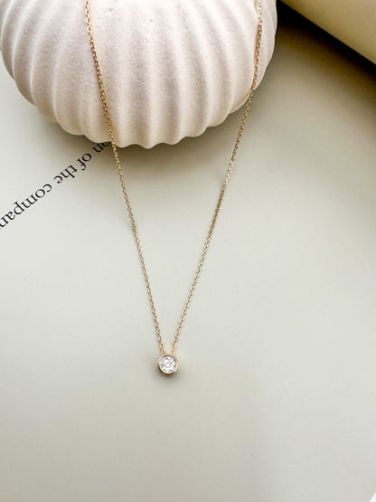 Velani Jewelry solitaire diamond necklace on a neutral background showcasing the 6.5mm pendant and delicate chain.