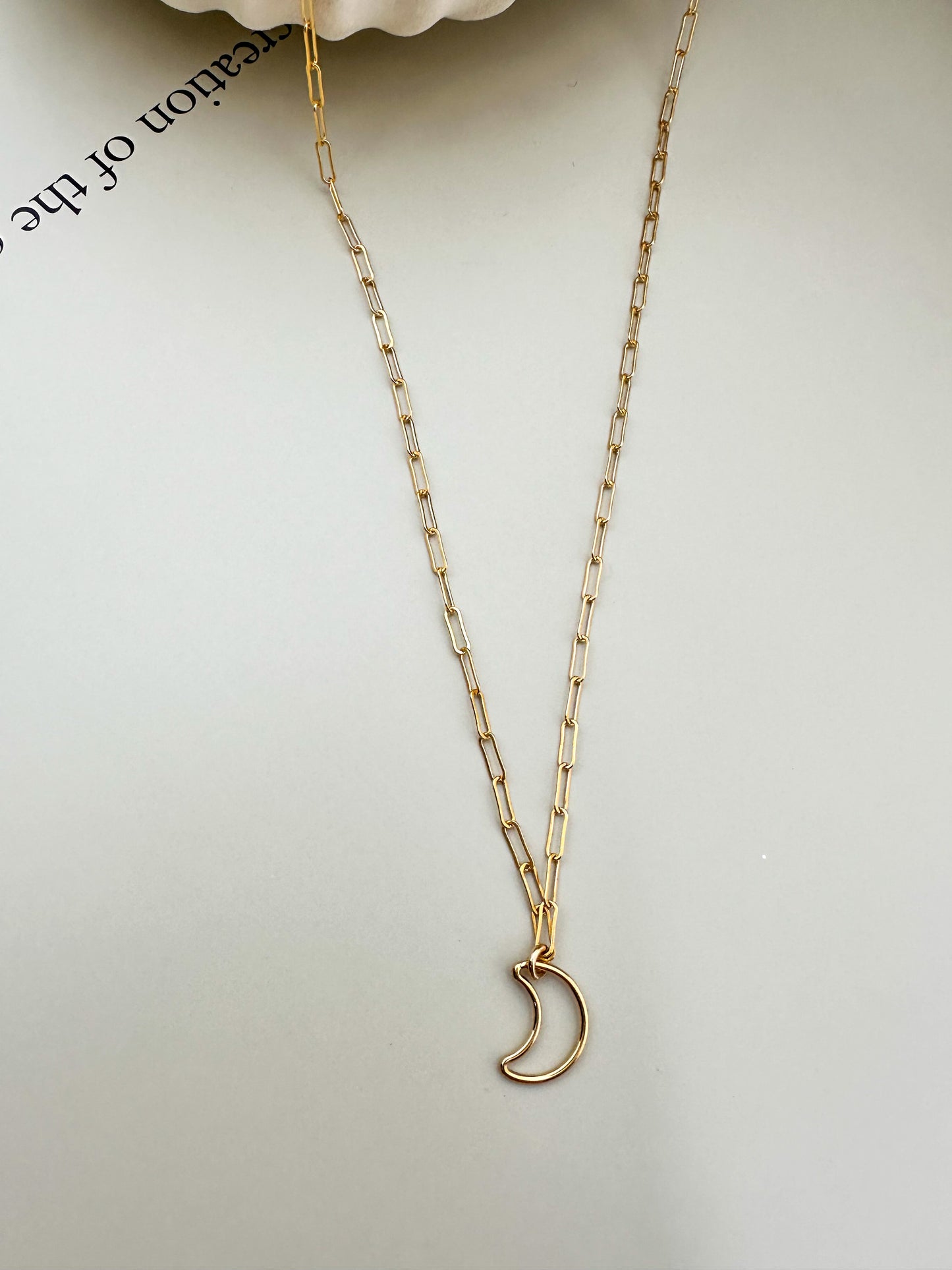 Velani Jewelry Lunar Paperclip Necklace with moon pendant on a neutral background.