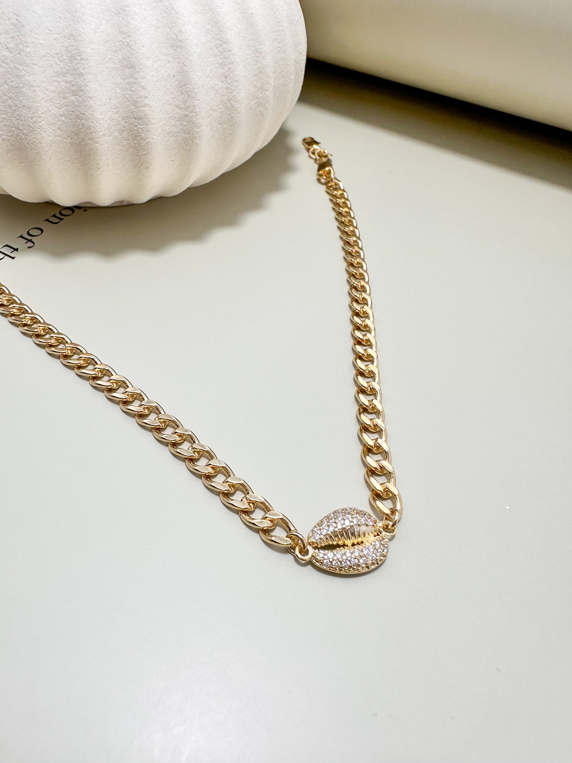 Velani Jewelry Cowrie Cuban Choker in 18K gold filled, featuring cubic zirconia, styled on a minimalist background.