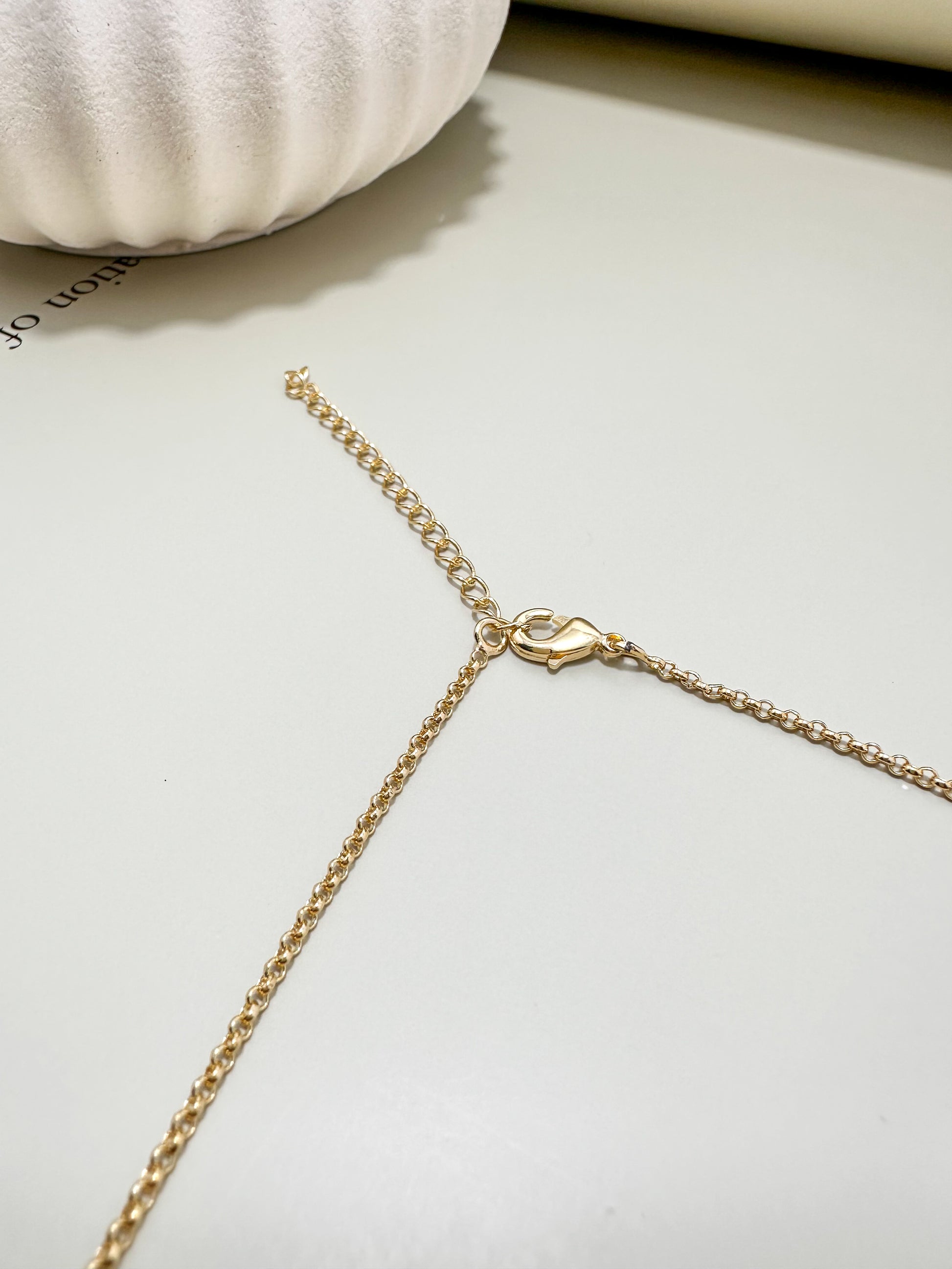 Velani Jewelry lariat necklace clasp and chain detail on a soft background, showcasing the 18K gold filled design.