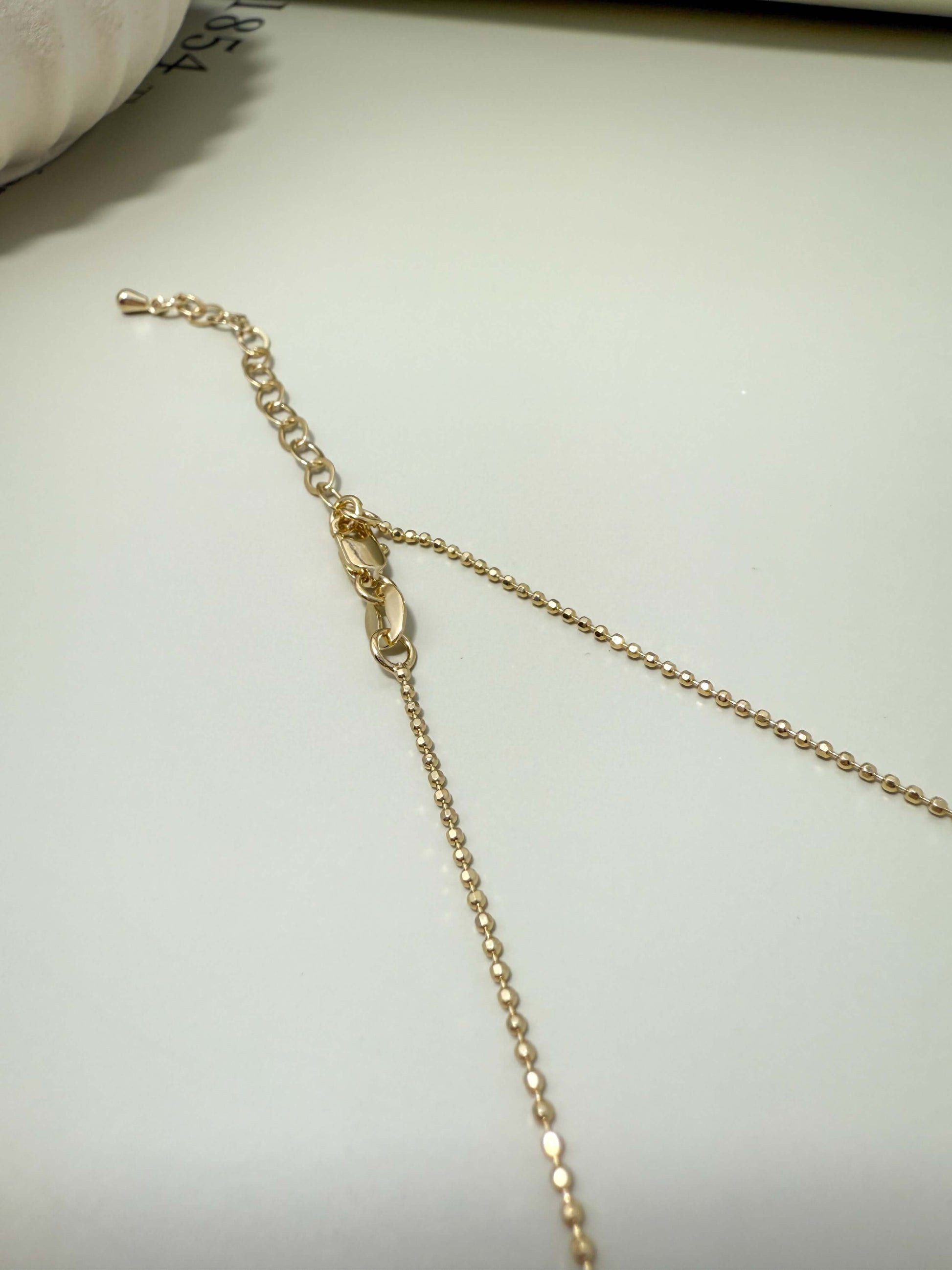 Close-up of the adjustable clasp and chain for Velani Jewelry Blessed Cross Plate Necklace, showcasing gold filled design.