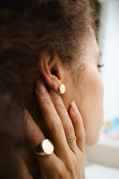 Woman wearing Velani Jewelry rounded ring and earrings in 18K gold-filled, showcasing high-quality craftsmanship and elegance.