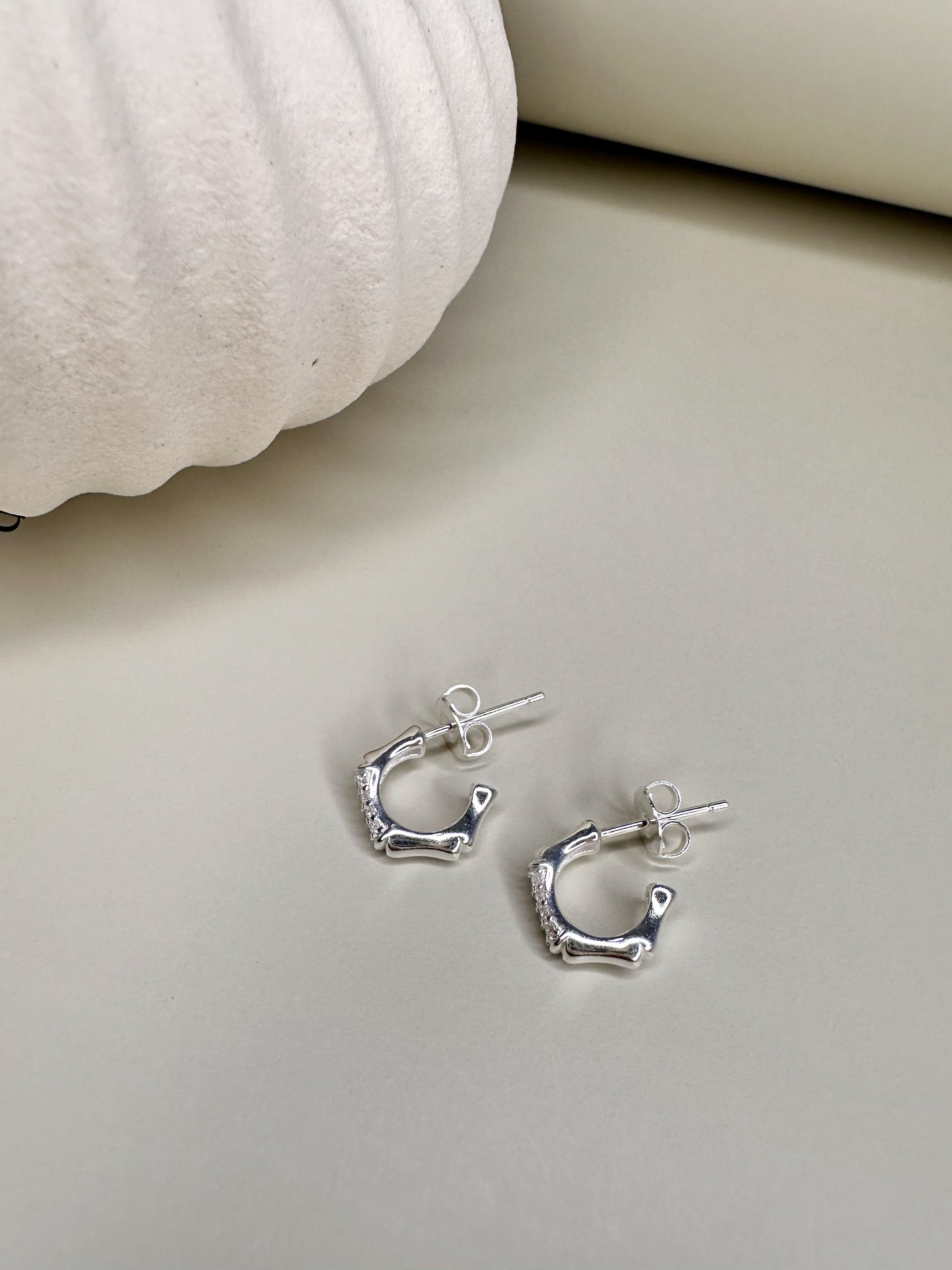 Sterling silver bamboo half hoop earrings by Velani Jewelry, handcrafted in Brazil, showcasing high-quality CZ stones.