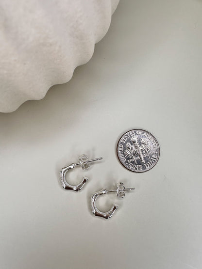 Velani Jewelry Bamboo Half Hoop Earrings in sterling silver next to a dime, illustrating size and design.