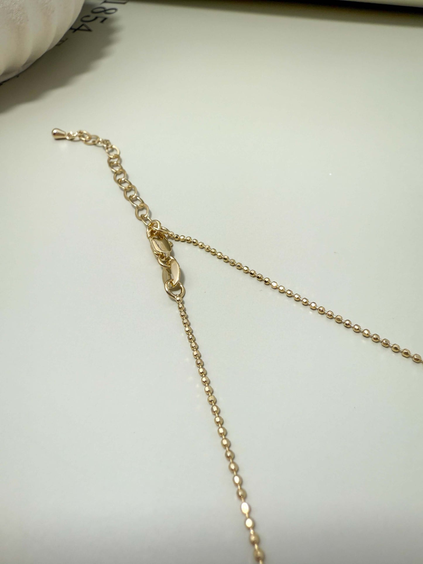 Close-up of the adjustable clasp and chain for Velani Jewelry Blessed Cross Plate Necklace, showcasing gold filled design.