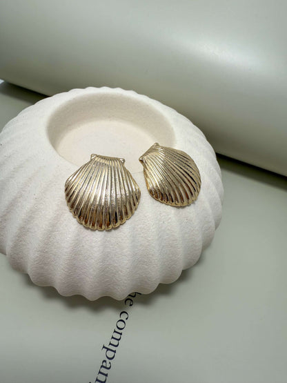 Elegant Velani Jewelry clam shell stud earrings in 18K gold filled, hypoallergenic, waterproof, and tarnish resistant for everyday wear.