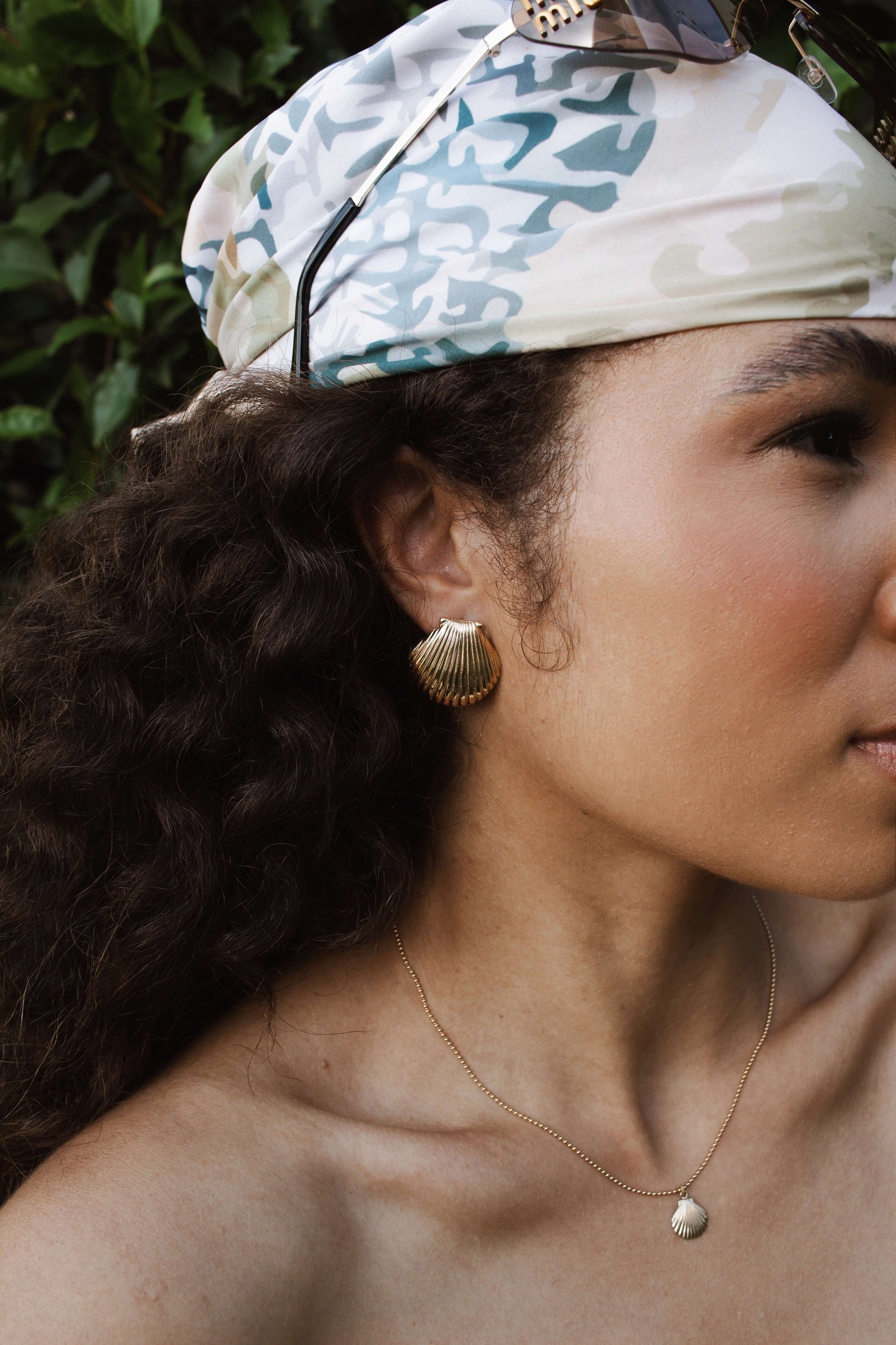 Close-up of a woman wearing Velani Jewelry 18K Gold Filled clam shell stud earrings, showcasing hypoallergenic and waterproof design.