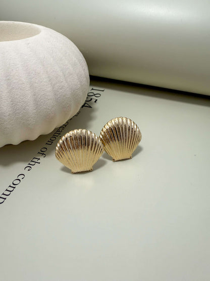 Velani Jewelry clam shell stud earrings, 18K gold filled, hypoallergenic, tarnish resistant, waterproof for everyday wear.