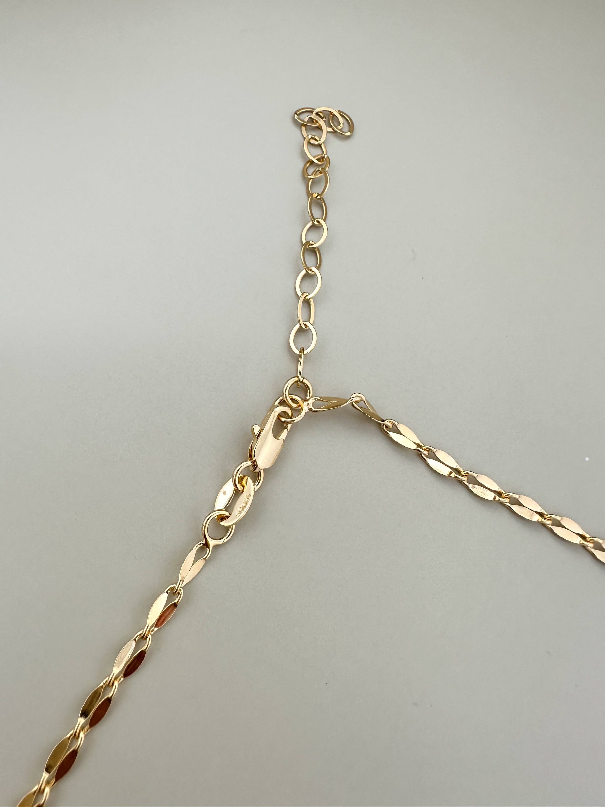 Close-up of the clasp and links of the Velani Jewelry Corrente Luxe Necklace in 18K gold filled finish.