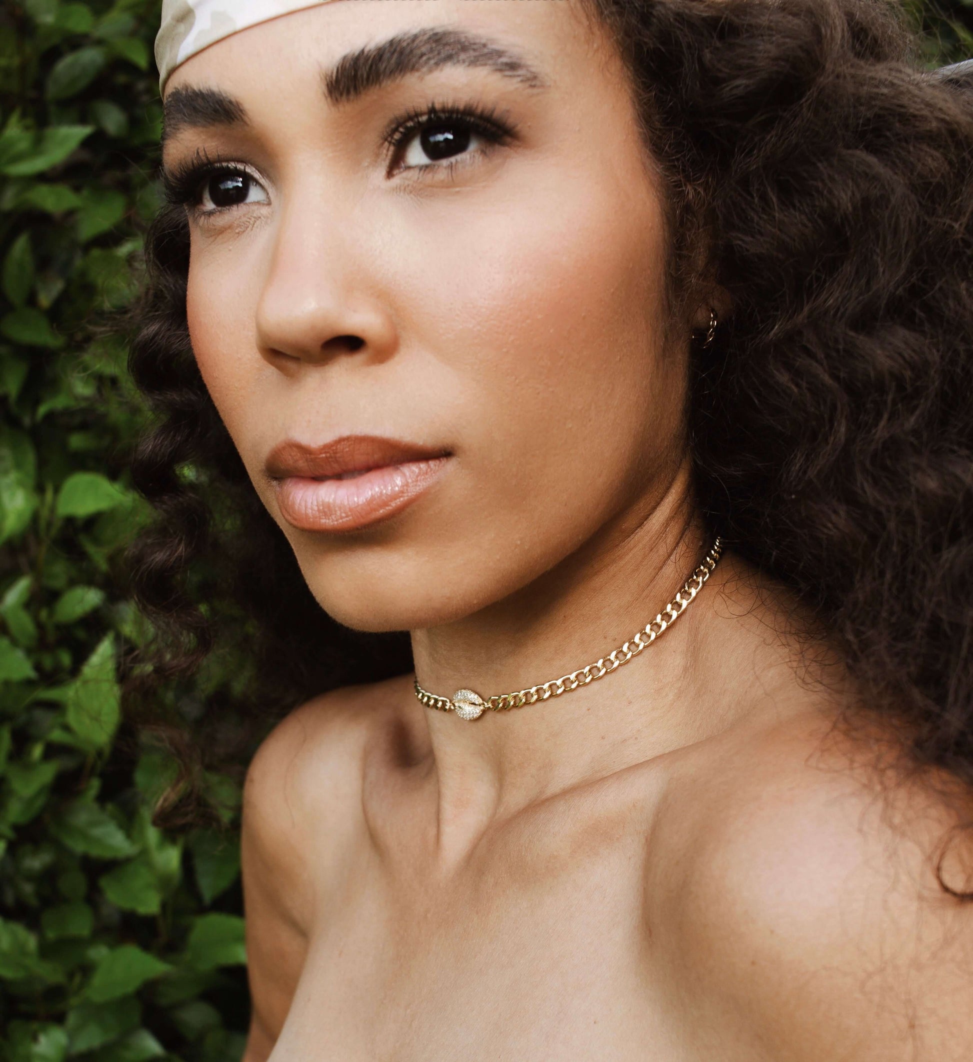Model wearing Velani Jewelry Cowrie Cuban Choker, a gold filled and hypoallergenic choker for everyday wear.