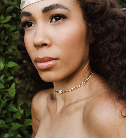 Model wearing Velani Jewelry Cowrie Cuban Choker, a gold filled and hypoallergenic choker for everyday wear.
