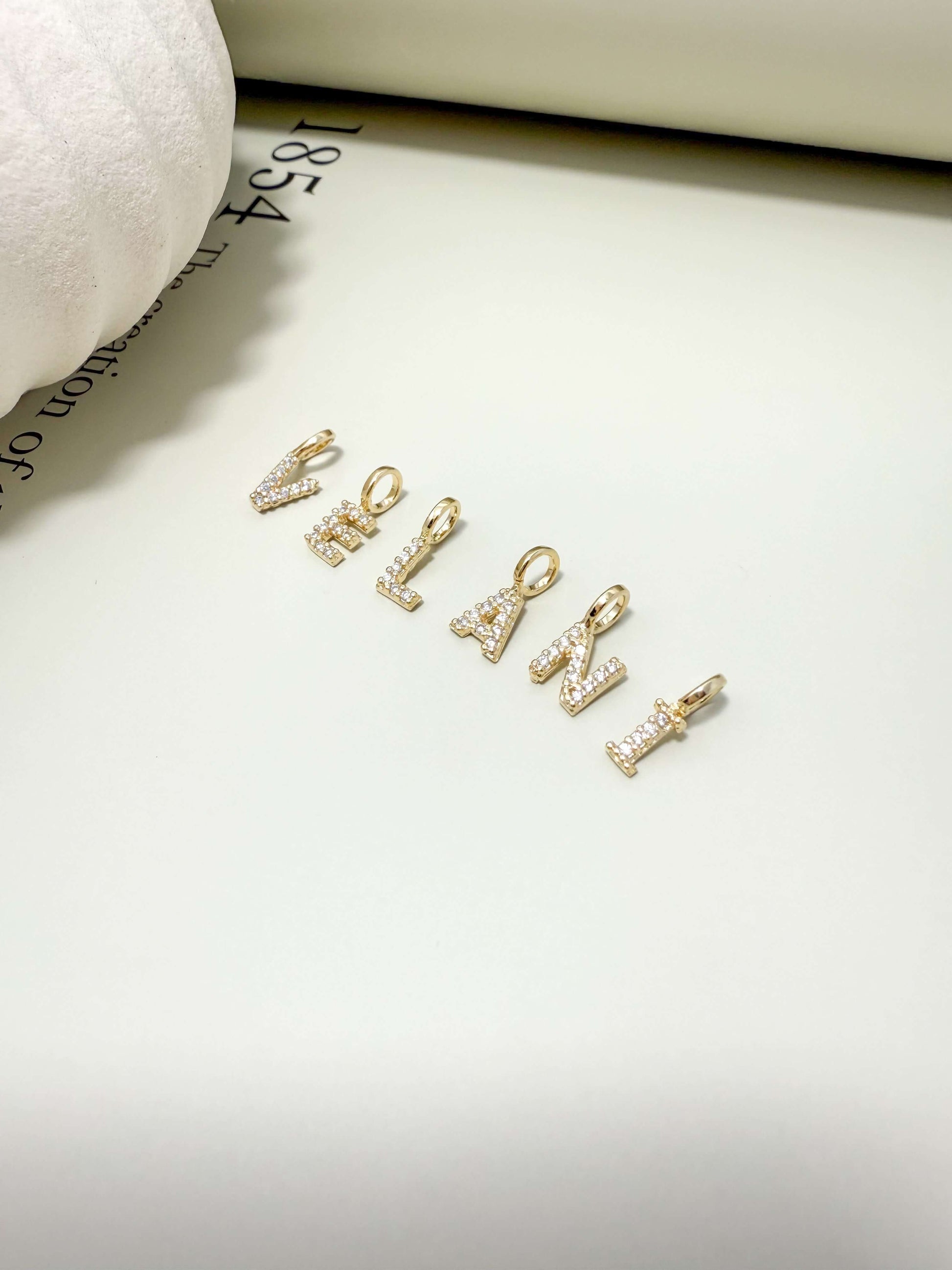 Dainty initial letter pendants with cubic zirconia, 18K gold filled, hypoallergenic and waterproof, perfect for everyday wear.