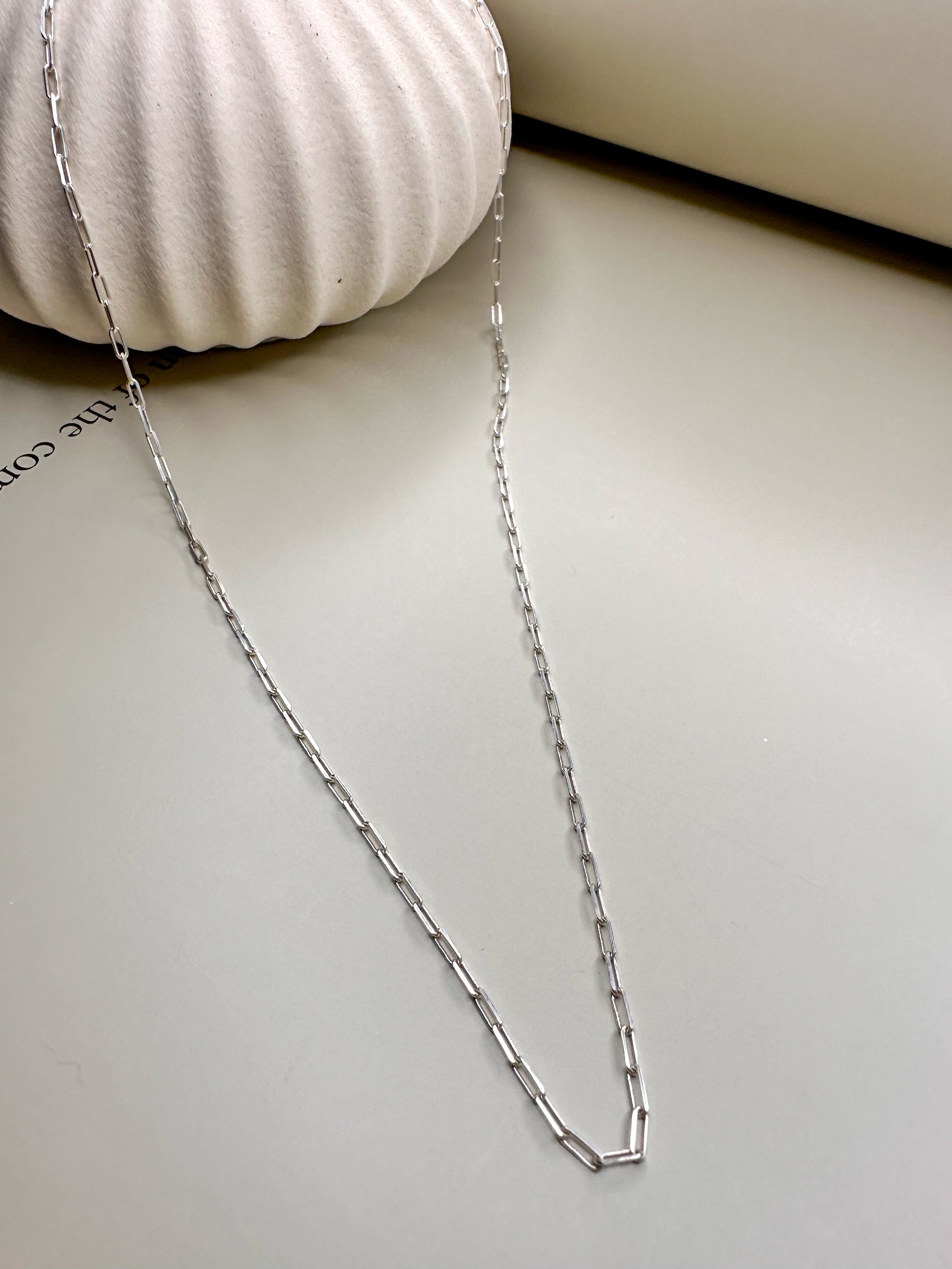 Velani Jewelry sterling silver paperclip necklace, handcrafted and nickel-free, displayed on a soft white surface.