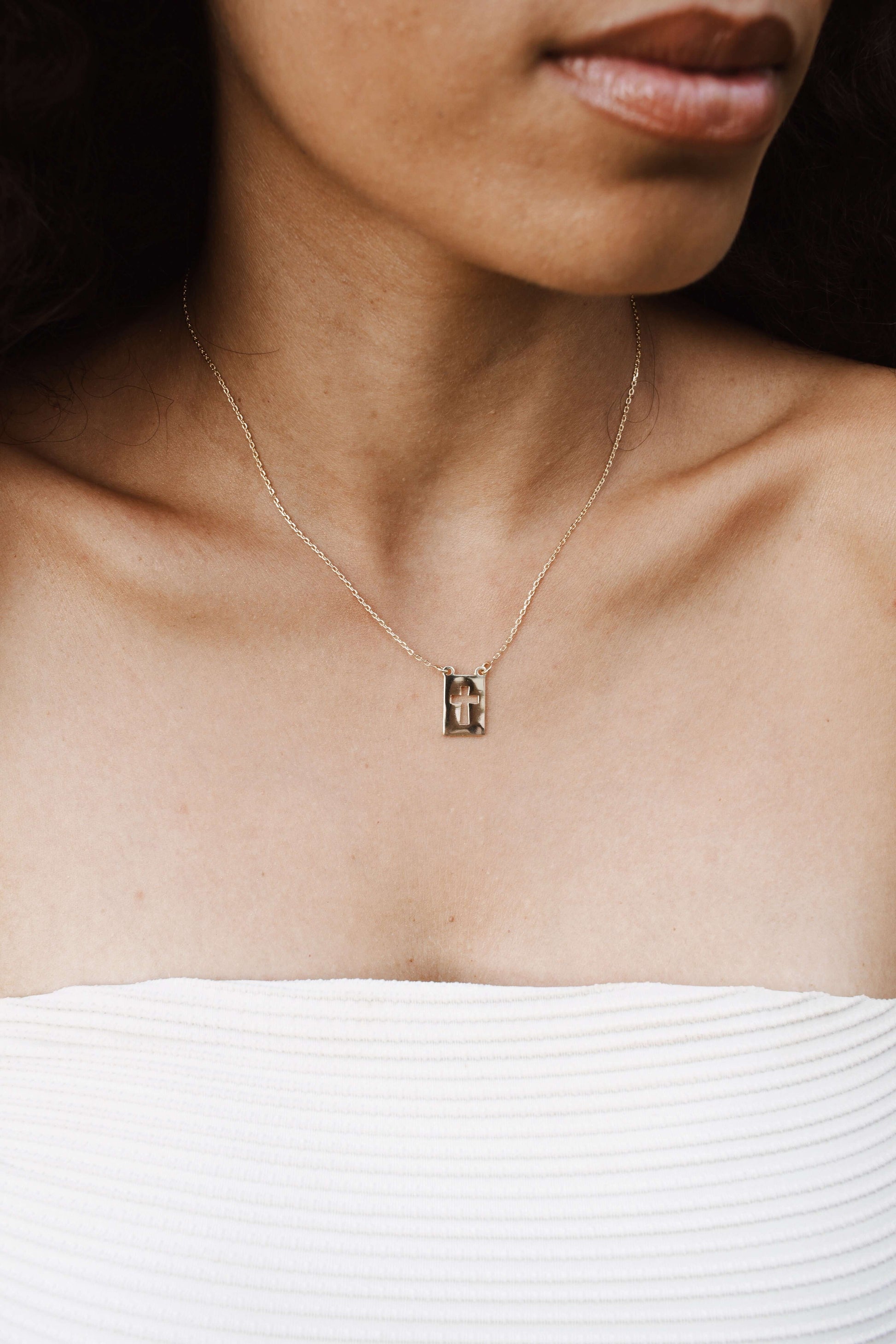 Model wearing Velani Jewelry El Shaddai Cross Plaque Necklace, a minimalist gold filled piece, perfect for everyday wear.