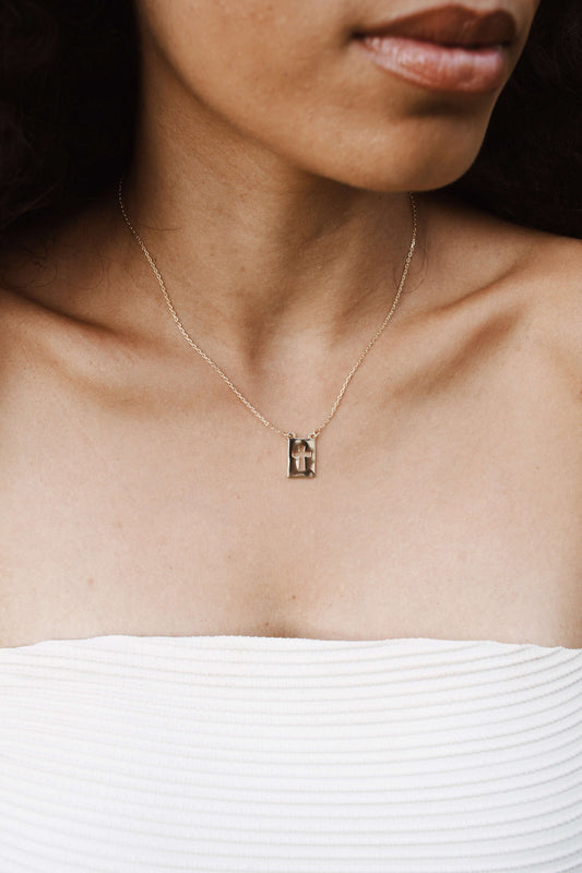 Model wearing Velani Jewelry El Shaddai Cross Plaque Necklace, a minimalist gold filled piece, perfect for everyday wear.