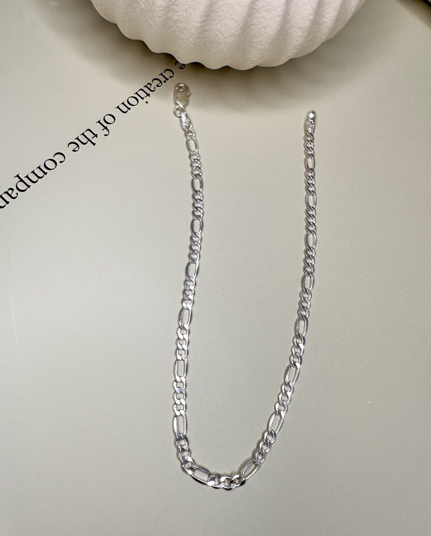 Velani Jewelry Figaro anklet in sterling silver, handcrafted in Brazil, displayed on a surface.