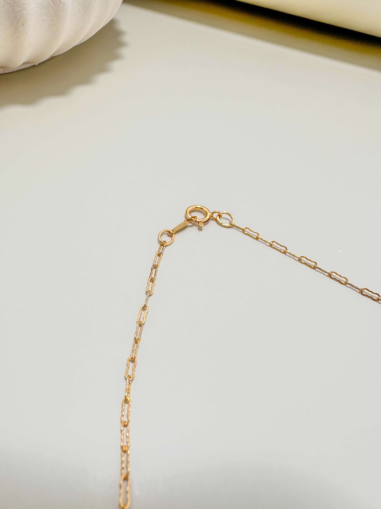 Close-up of the clasp on a Velani Jewelry gold filled flat krinkle necklace, showcasing its tarnish resistant and waterproof design.