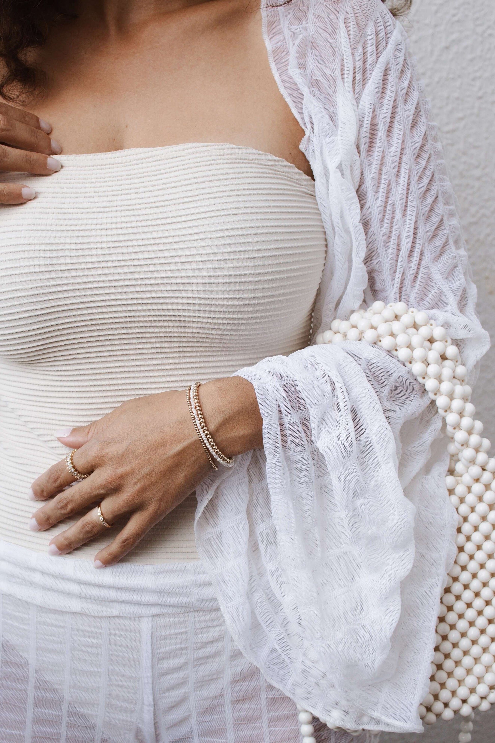 Close-up of a woman wearing a Velani Jewelry Micro Freshwater Pearl Bracelet, showcasing its handcrafted elegance and hypoallergenic features.