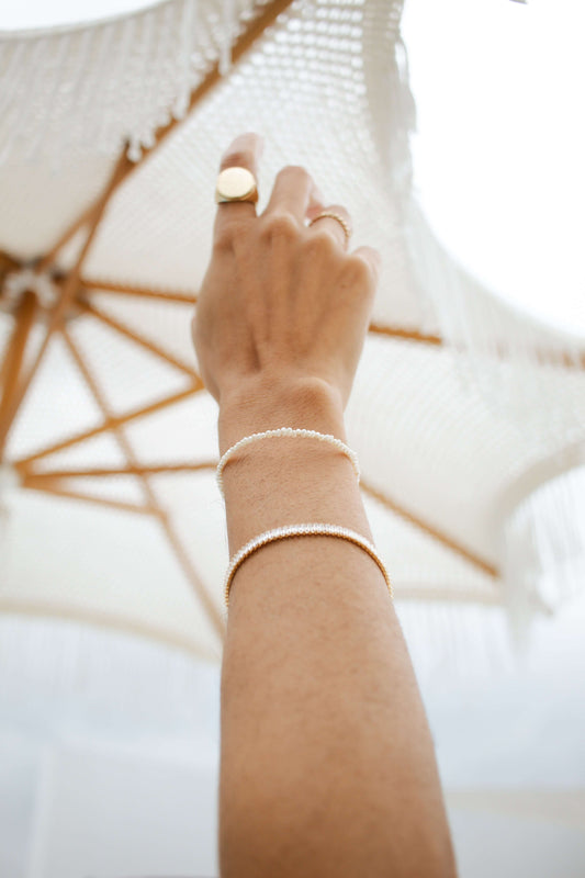 Model wearing Velani Jewelry Micro Freshwater Pearl Bracelet, showcasing its hypoallergenic, waterproof, and gold filled features.