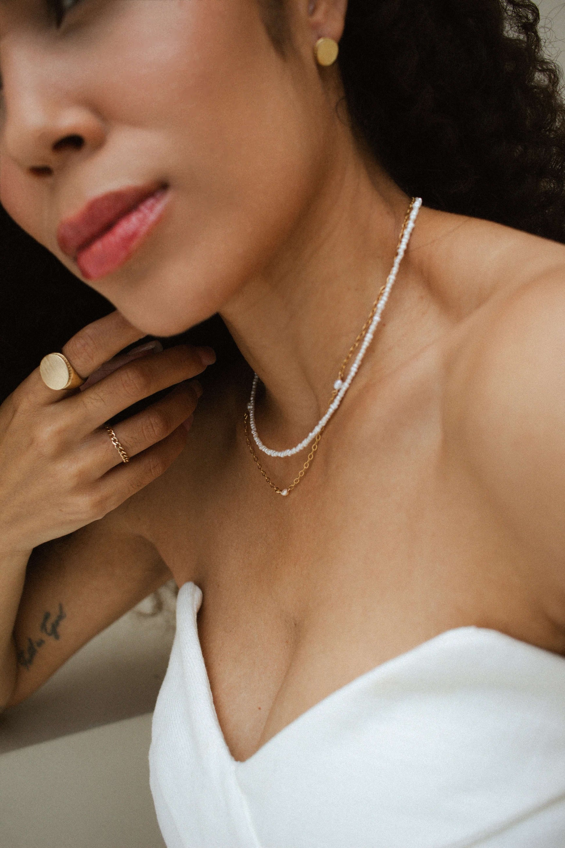 Model showcasing Velani Jewelry Micro Freshwater Pearl Necklace, gold filled, hypoallergenic, waterproof, perfect for everyday wear.