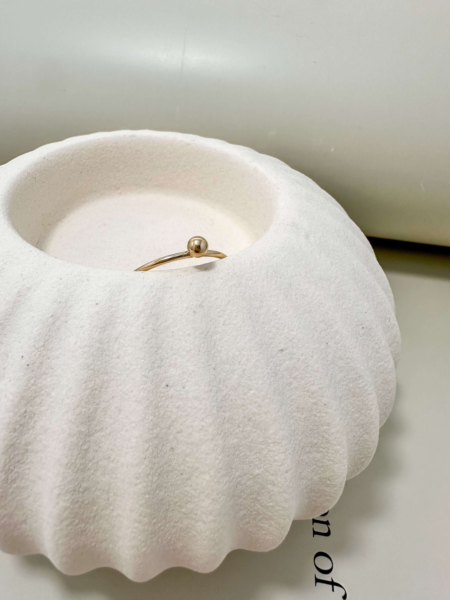Velani Jewelry single ball stacking ring in a white dish, 14K gold filled, hypoallergenic, waterproof, tarnish resistant.